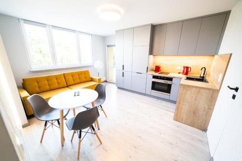una cucina e un soggiorno con divano giallo e tavolo di Apartament Piano Centrum a Racibórz