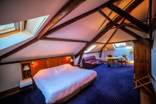 ein Schlafzimmer mit einem Bett und einem Tisch im Dachgeschoss in der Unterkunft Hotel d'Angleterre in Châlons-en-Champagne