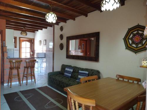 a living room with a green couch and a table at Chale da Ana in Santo Antônio do Pinhal