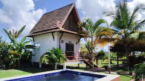 a villa with a pool in front of a house at Pousada Thai Bungalows-Taipu de Fora in Barra Grande