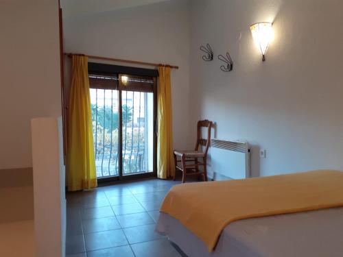 a bedroom with a bed and a window and a chair at La Caseta Benimantell in Benimantell