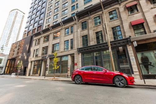 a red car parked in front of a building at Le Dauphin Montréal Centre-Ville in Montréal