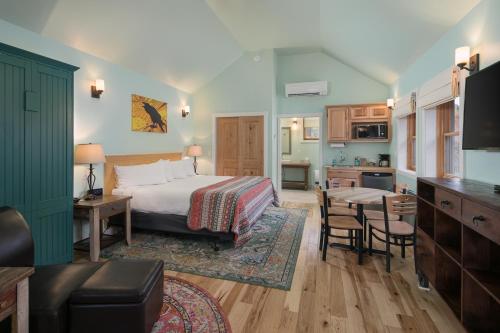 a hotel room with a bed, table, chairs and a television at Moab Springs Ranch in Moab
