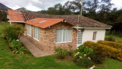 une petite maison en briques dans un jardin dans l'établissement Finca San Carlos 100% pet friendly, à Zipaquirá