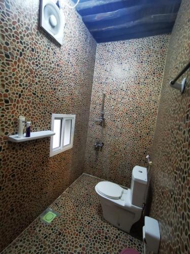 a bathroom with a toilet and a window at Misfah Old House in Misfāh