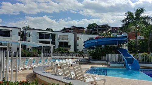 a pool with a slide and chairs and a slidesktopktop at Ciudadela Santa fe Apartasol 4 A 2 in Santa Fe de Antioquia