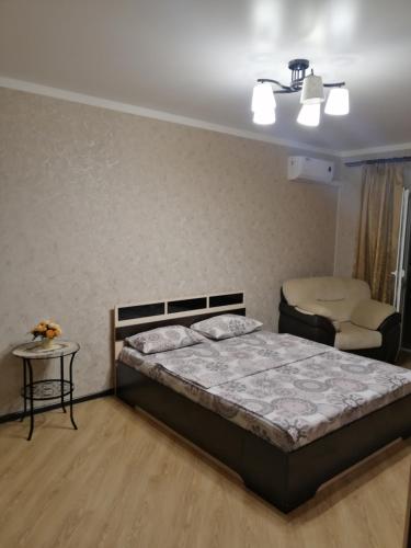 a bedroom with a bed and a table and a chair at Московская улица, 97 Апартаменты 5этаж in Pyatigorsk