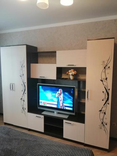 a living room with a tv and white cabinets at Московская улица, 97 Апартаменты 5этаж in Pyatigorsk