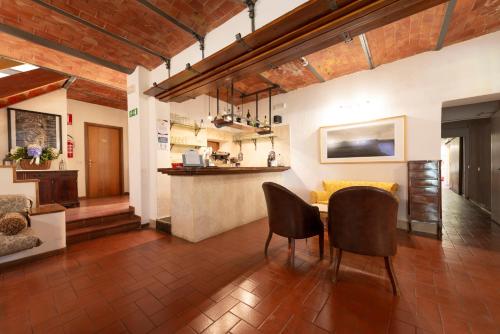 a living room with a table and chairs in it at Hotel Palazzuolo in San Quirico dʼOrcia