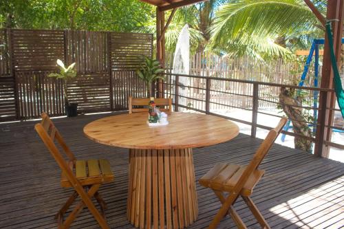 een houten tafel en stoelen op een terras bij Pedacinho do Paraiso Pousada in Jijoca de Jericoacoara