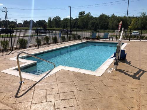 a swimming pool with a metal hand rail next to it at avid hotel Tulsa South - Medical District by IHG in Tulsa