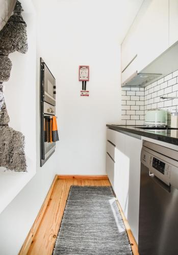 a kitchen with a rug on the floor at Casas da Ribeira in Santa Bárbara