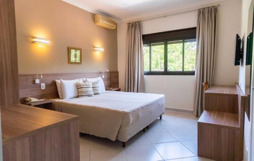 ein Hotelzimmer mit einem Bett und einem Fenster in der Unterkunft Guararema Parque Hotel in Guararema