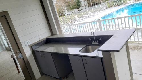 a kitchen with a sink and a swimming pool at Comfy 1BR Apartment - Ideal for Traveling Nurses & Professionals in Gainesville