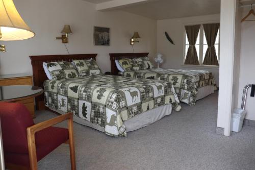 a hotel room with two beds and a table at Olympus Lodge in Estes Park
