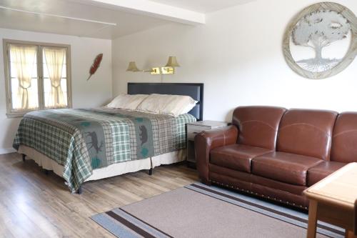 een slaapkamer met een bed en een leren bank bij Olympus Lodge in Estes Park