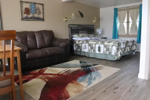 a living room with a couch and a bed at Olympus Lodge in Estes Park