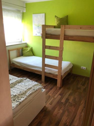 2 Etagenbetten in einem Zimmer mit grünen Wänden in der Unterkunft Ferienwohnung Unterwellenborn in Unterwellenborn