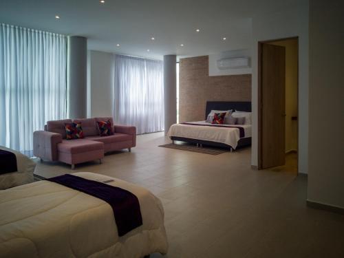 a hotel room with two beds and a couch at Hotel Boutique M in Barranquilla