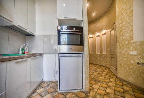 a kitchen with white cabinets and a dishwasher at Apartment on Kommunisticheskaya in Smolensk