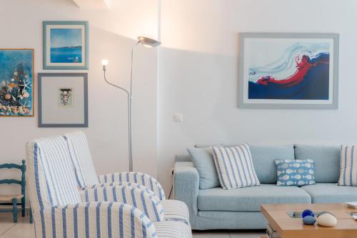 sala de estar con 2 sillas y sofá en Beachfront Modern Apartment, en Eretria