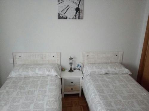 two beds sitting next to each other in a bedroom at Apartamento LA FRAGUA in Comillas