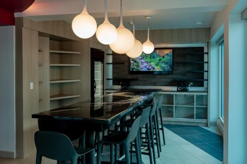a kitchen with a bar with chairs and a tv at The Tryst Beachfront Hotel in San Juan