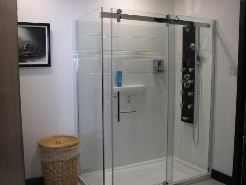 een douche met een glazen deur in de badkamer bij Magnolia B&B in Granby