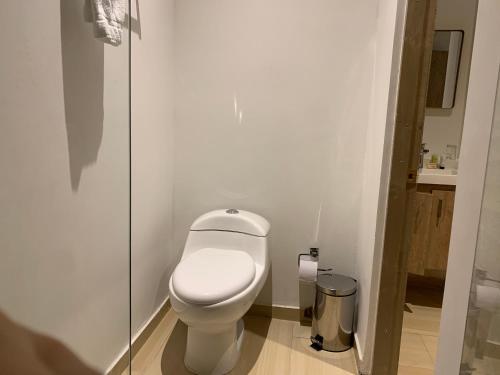 a white toilet in a bathroom with a glass door at Hotel Boutique M in Barranquilla