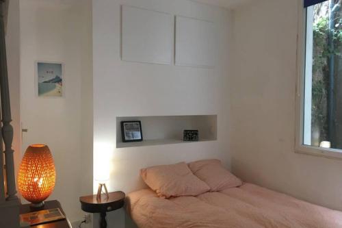 sypialnia z łóżkiem, lampką i oknem w obiekcie Appartement plein centre Nantes w mieście Nantes
