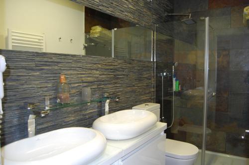 baño con 2 lavabos y ducha de cristal en Apartamento Garona, en Vielha
