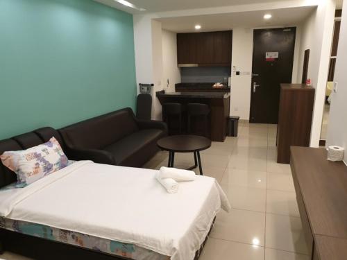 a bedroom with a bed and a couch and a kitchen at Studio Suite Genting Highland 32 in Genting Highlands