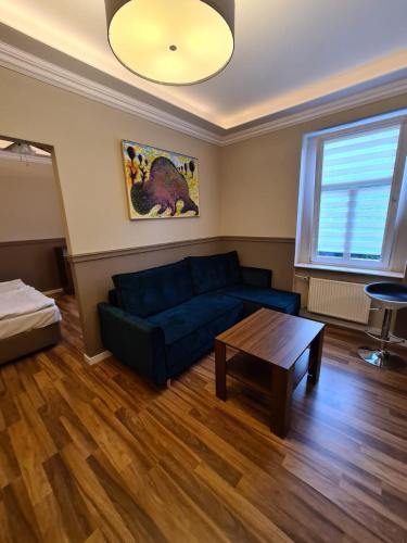 a living room with a blue couch and a table at APART LuX BRISTOL in Bytom
