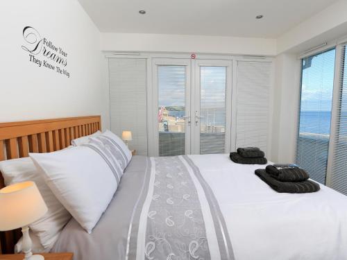 a bedroom with two beds and a window with the ocean at 1 At The Beach in Beesands