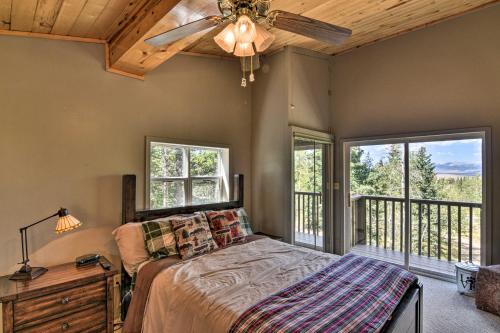 1 dormitorio con 1 cama, ventilador de techo y ventanas en Woodsy Cabin Hideaway with Deck Hike, Fish, Escape, en Bordenville