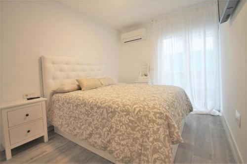 biała sypialnia z łóżkiem i oknem w obiekcie FH ALTEA CENTRO PLAYA w Altei