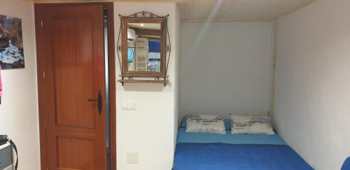 Schlafzimmer mit einem Bett, einem Spiegel und einer Tür in der Unterkunft La Casita Azul in Alora