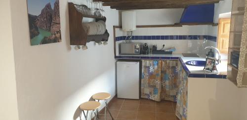 a kitchen with a counter and stools in it at La Casita Azul in Alora