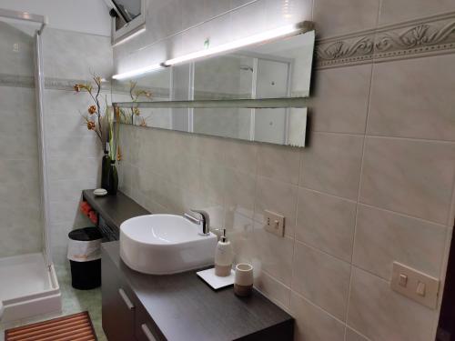 bagno con lavandino e specchio di Angolo Relax a Terracina
