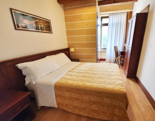 a hotel room with a bed and a window at Hotel Aurora in Verona