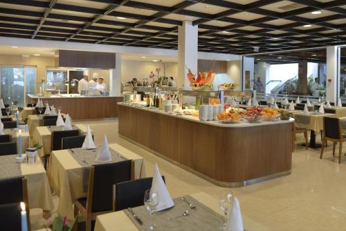 Un restaurante con mesas y sillas y un buffet. en Village Galijot Plava Laguna, en Poreč