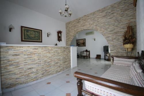 a living room with a brick wall and a bench at Aegeon Hotel in Naxos Chora