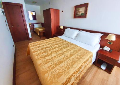 a hotel room with a large bed and a desk at Hotel Aurora in Verona