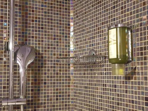 a tiled wall in a bathroom with a shower at Hotel Aurora in Verona