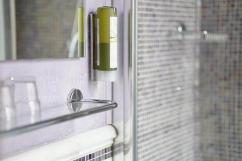 a bathroom with a window with a green candle at Hotel Aurora in Verona