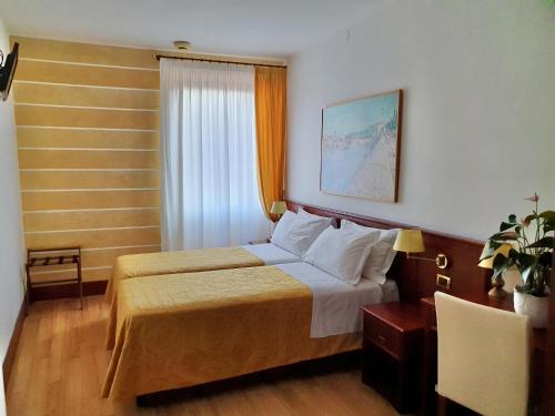 Hotel Aurora في فيرونا: غرفه فندقيه بسرير ونافذه