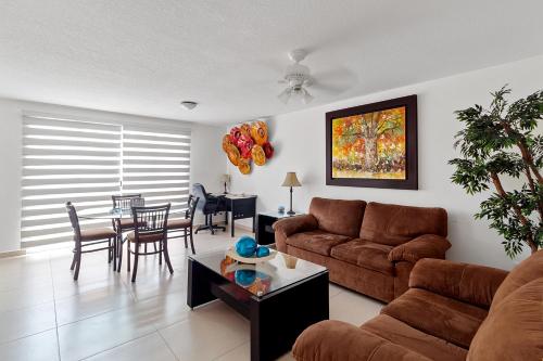a living room with a couch and a table at Acogedora Suite Alberca Bernardo Quintana 3B in Mendiola