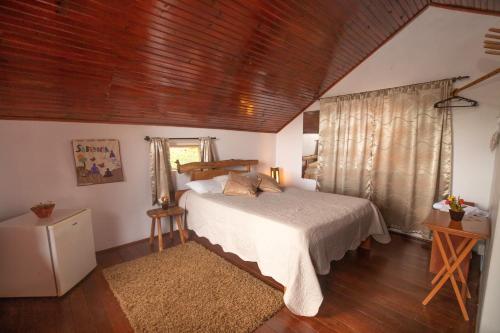 um quarto com uma cama e um tecto de madeira em Buddy's Hostel & Pousada Alto Paraiso em Alto Paraíso de Goiás