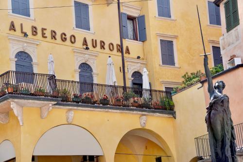 a building with a statue in front of a bergamo embassy at Hotel Aurora in Verona
