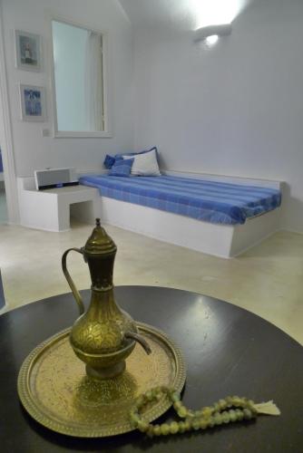a room with a table with a vase and beads on it at Altana Heritage Suites in Imerovigli